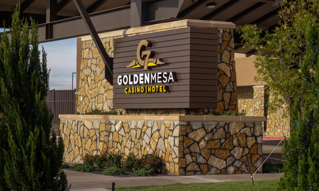 Golden Mesa Casino & Hotel entrance sign with stonework, landscaping and warm exterior lighting in Guymon, Oklahoma.