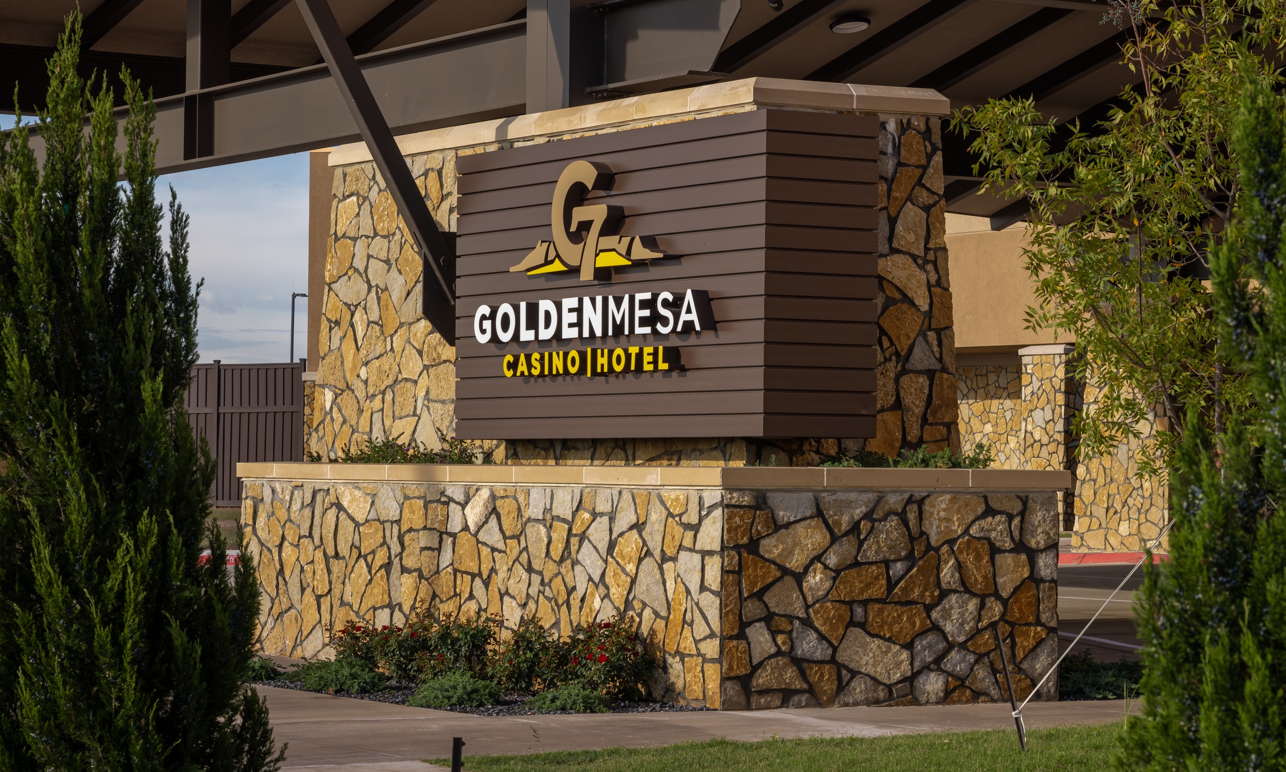 Golden Mesa Casino & Hotel entrance sign with stonework, landscaping and warm exterior lighting in Guymon, Oklahoma.