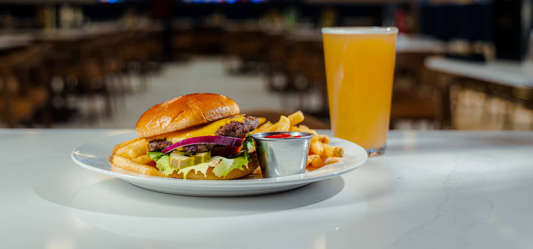Cheeseburger with fries and a pint of beer served on the bar at Cimarron Ridge Restaurant inside Golden Mesa Casino & Hotel.