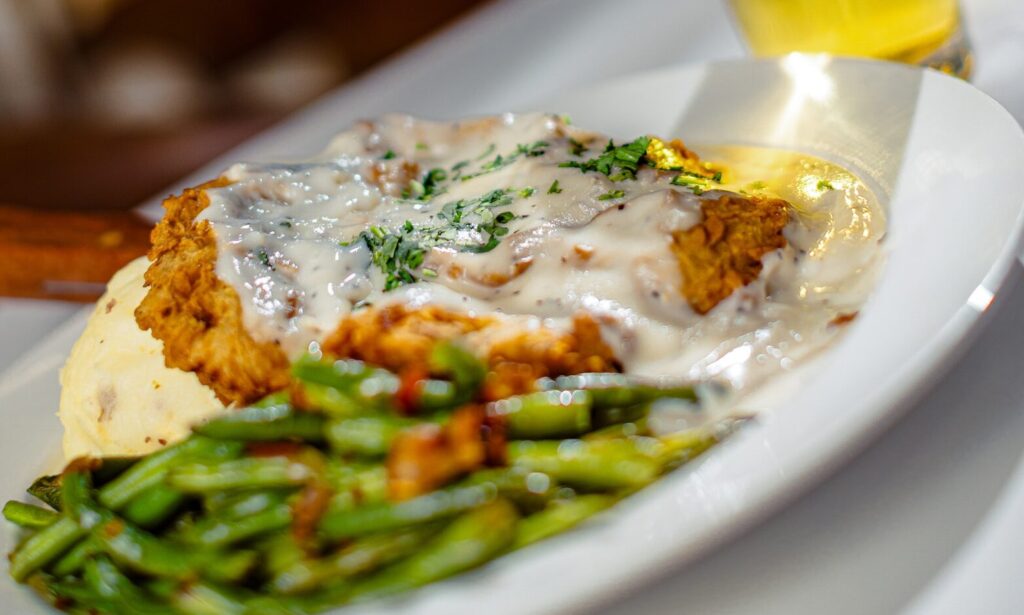 Chicken fried steak topped with creamy gravy, served with mashed potatoes and green beans at Golden Mesa's Cimarron Ridge Restaurant.