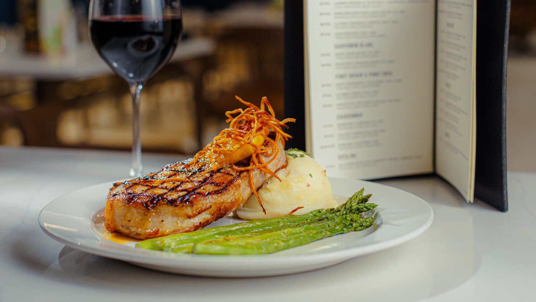 Grilled pork chop with mashed potatoes, asparagus and red wine served at Golden Mesa's Cimarron Ridge Restaurant.