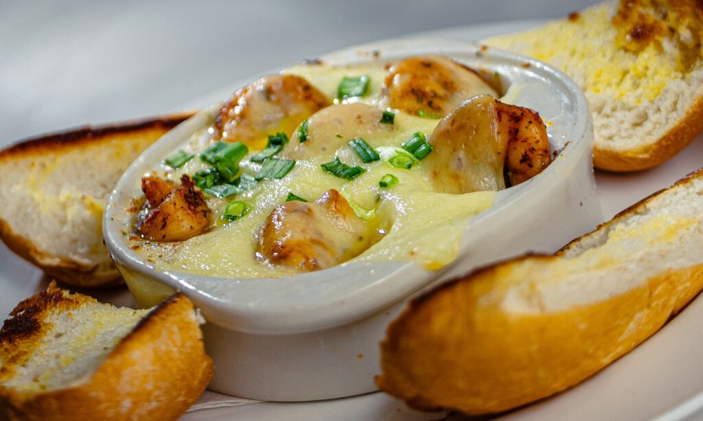 Shrimp Cargot appetizer baked with garlic butter and cheese, served with toasted bread at Golden Mesa's Cimarron Ridge Restaurant.