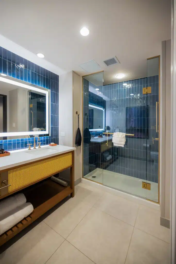 King Deluxe bathroom with glass shower, deep blue tile, illuminated mirror and wide vanity at Golden Mesa Hotel.