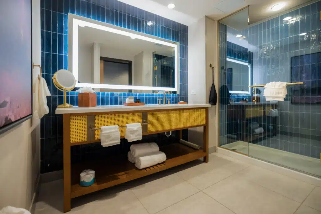 King Deluxe bathroom with glass shower, deep blue tile, illuminated mirror and wide vanity at Golden Mesa Hotel.
