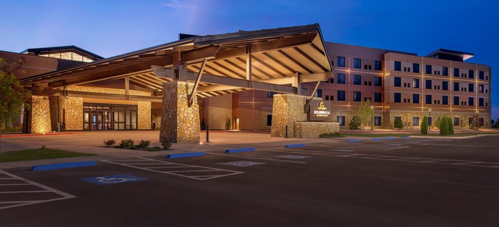 Golden Mesa Casino & Hotel exterior at dusk with covered entrance, stone columns, hotel tower and accessible parking.