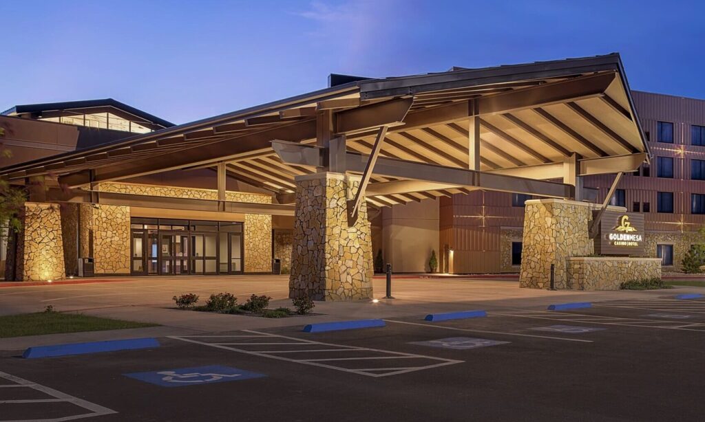 Golden Mesa Casino & Hotel exterior at dusk with covered entrance, stone columns, hotel tower and accessible parking.