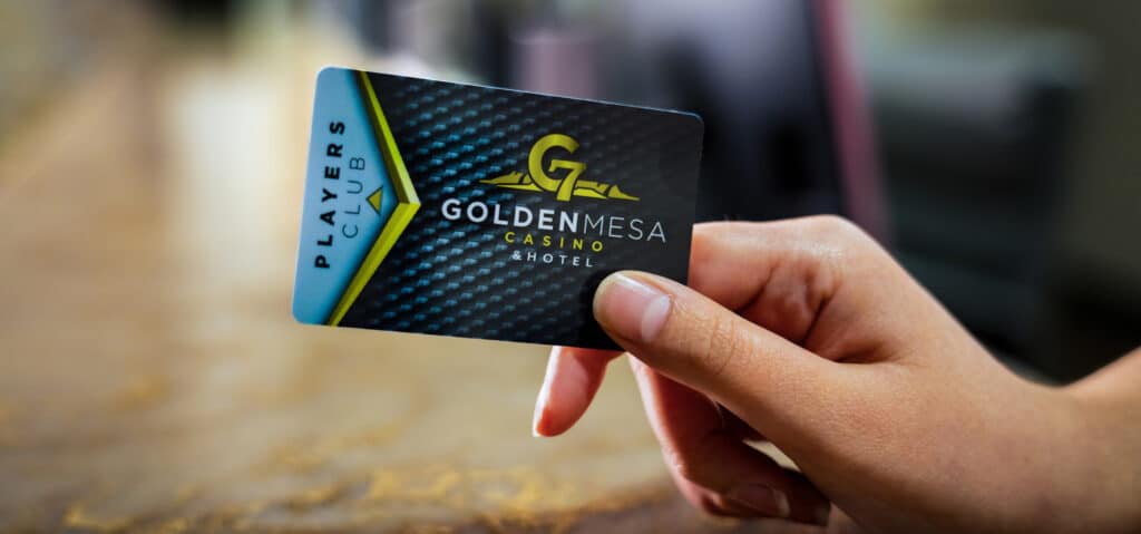 Close-up of a hand holding a Golden Mesa Casino Players Club card with the casino logo visible.