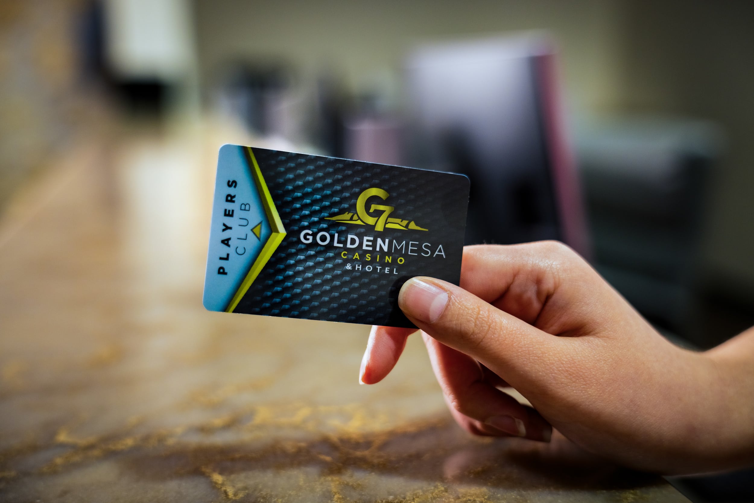 Close-up of a hand holding a Golden Mesa Casino Players Club card with the casino logo visible.
