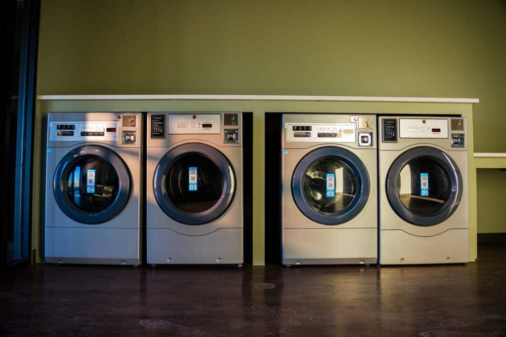 Laundry room with four washer and dryer machines in The Park building at the Golden Mesa Casino RV Park in Guymon, Oklahoma.