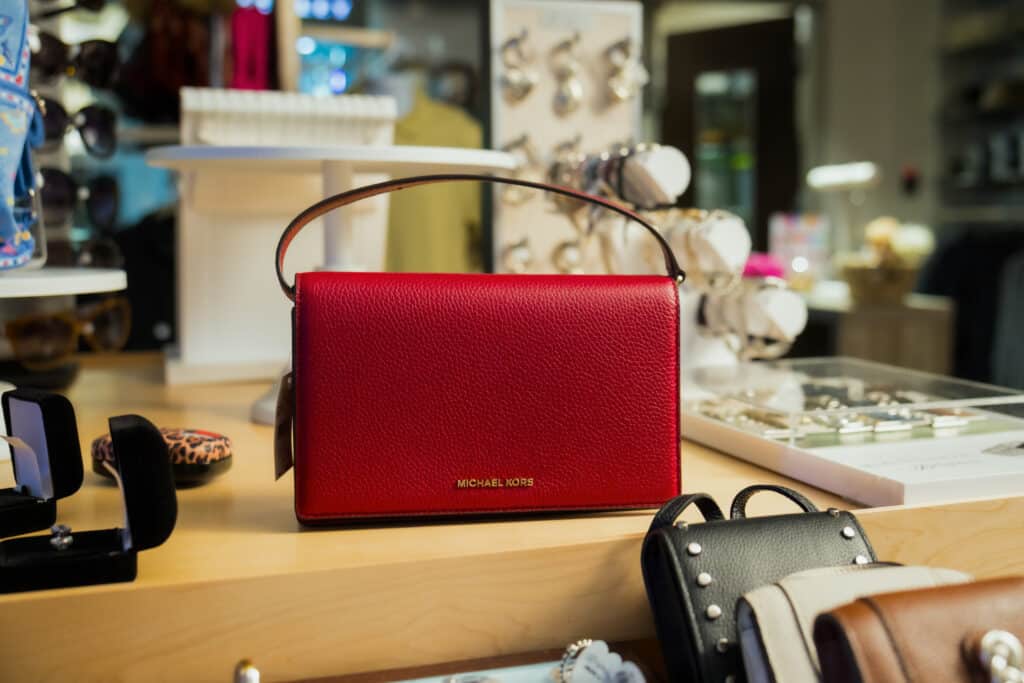 Red Michael Kors purse displayed with jewelry and accessories at Silver Saddle Gift Shop inside Golden Mesa Casino & Hotel.