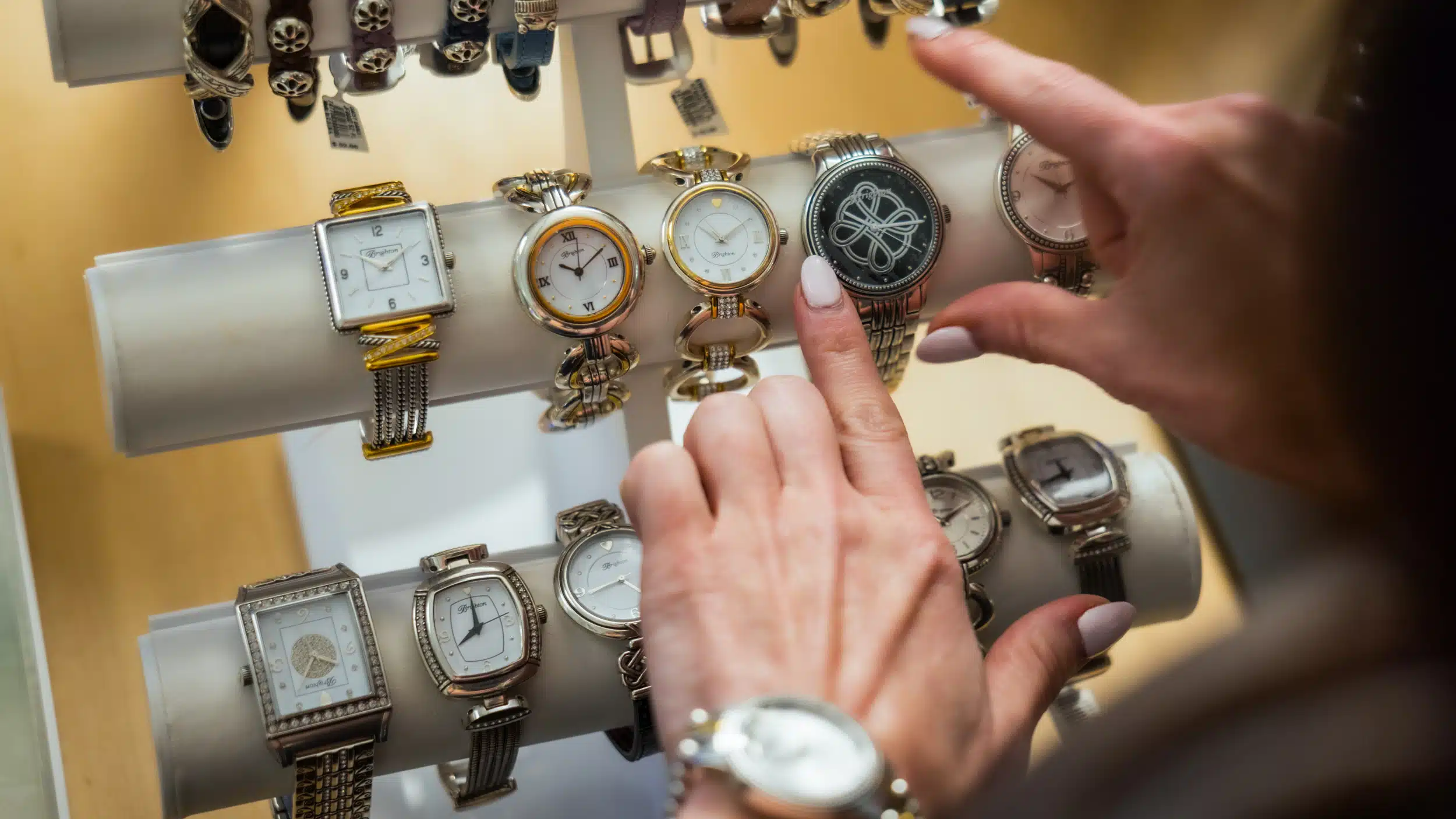 Close-up of a guest’s hands browsing watches at Silver Saddle Gift Shop inside Golden Mesa Casino & Hotel.