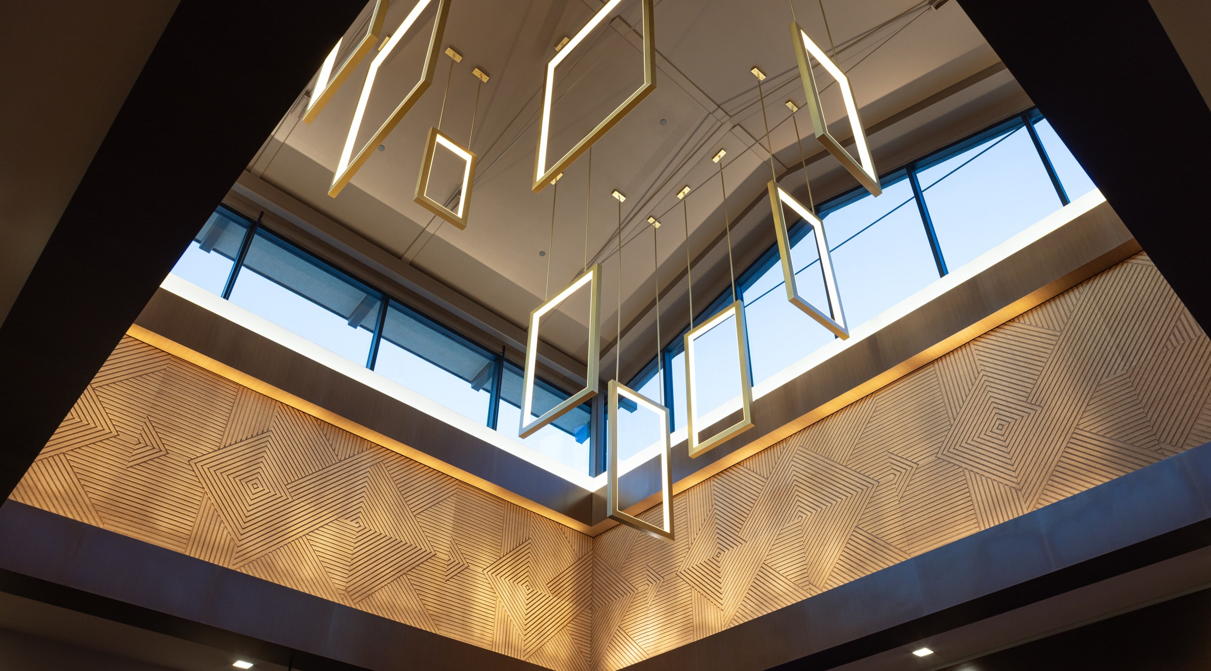 Hotel lobby skylight with hanging geometric light installation and warm patterned walls at Golden Mesa Casino & Hotel.