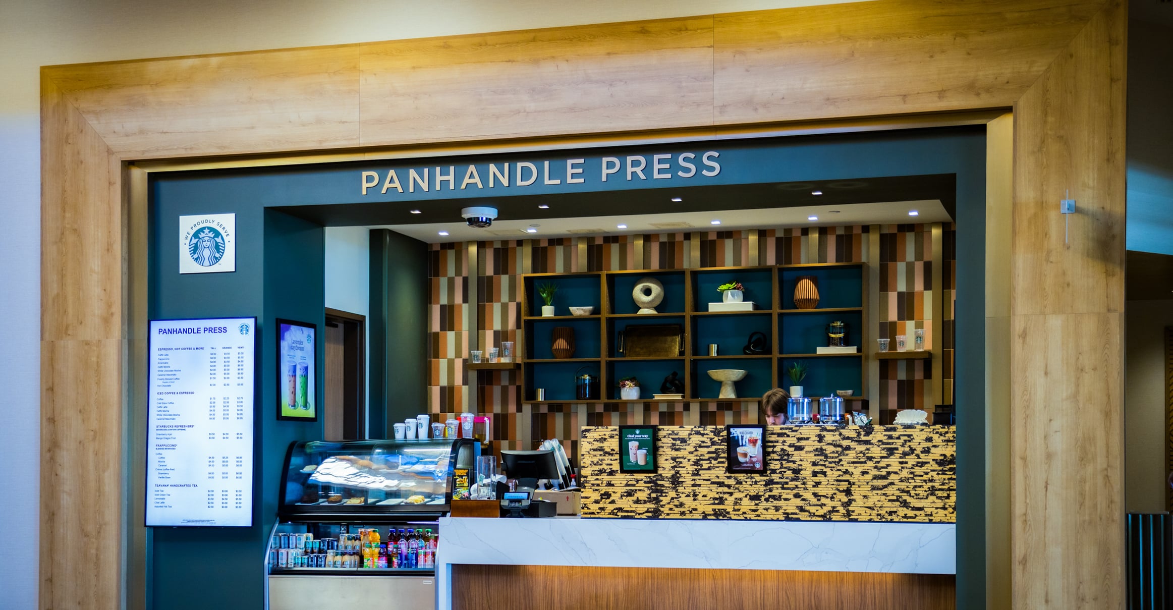Panhandle Press Coffee Shop with wood framing, menu screens, pastry case and Starbucks coffee inside Golden Mesa Hotel lobby.