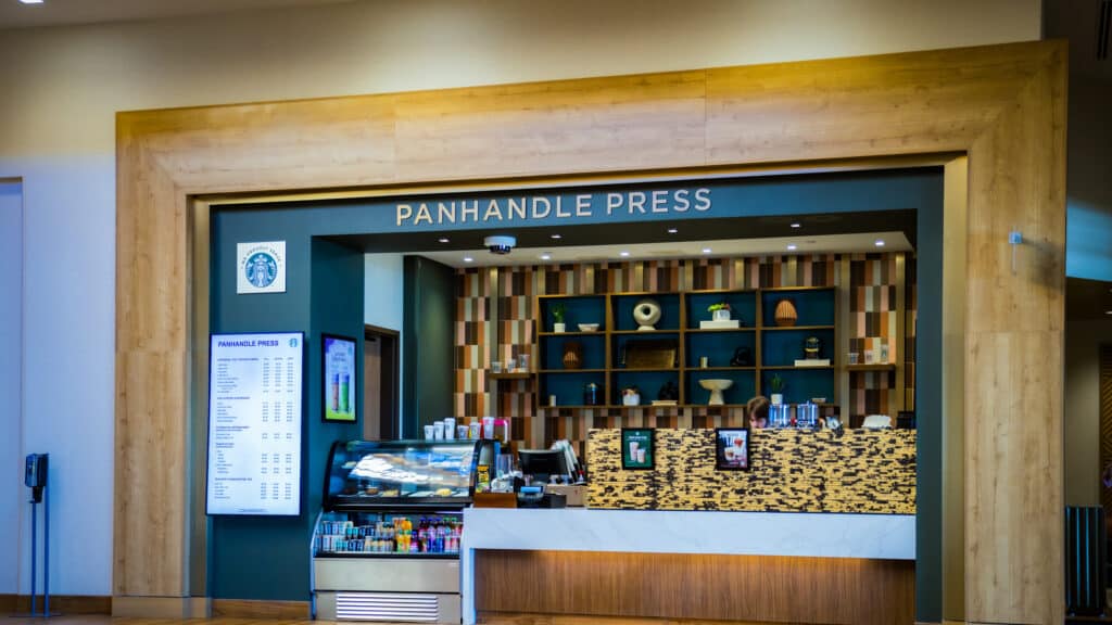 Panhandle Press Coffee Shop with wood framing, menu screens, pastry case and Starbucks coffee inside Golden Mesa Hotel lobby.